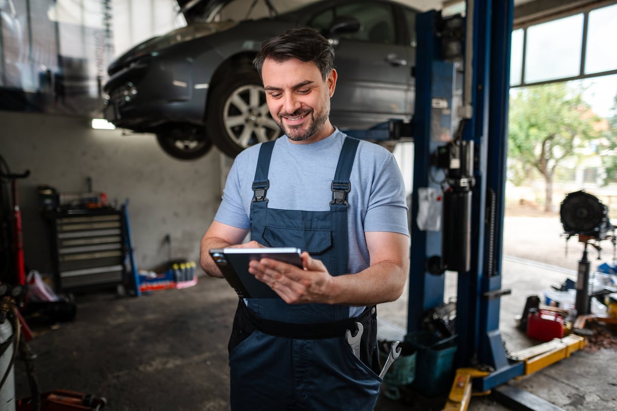 Auto repair shop interior with car on hydraulic lift
